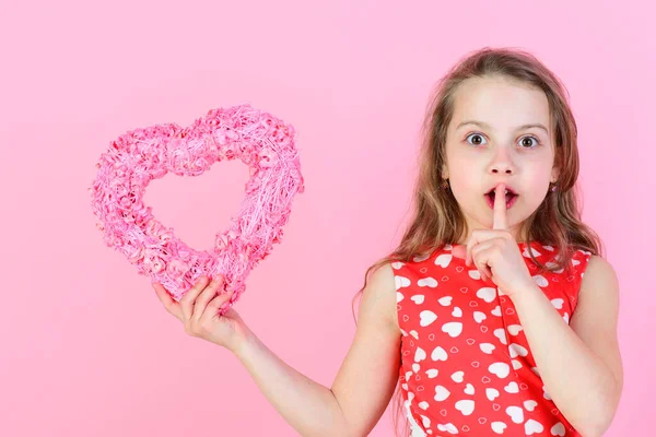 Concepto de amor romántico Chica sorprendida sosteniendo el corazón rosado sobre fondo rosa . — Foto de Stock