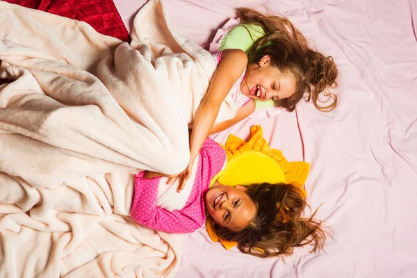 Gyerekek boldog arccal fekszenek rózsaszín háttér, felső nézet — Stock Fotó