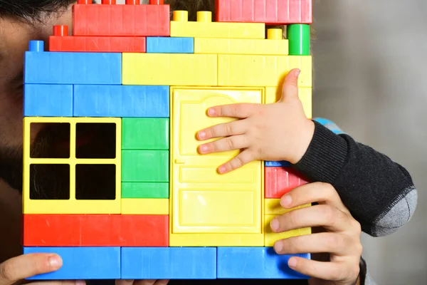 Dad and kid hide behind building wall made of blocks — Stock Photo, Image