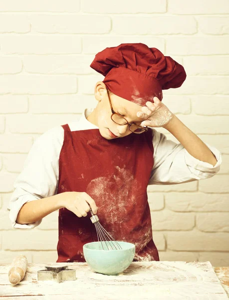 Manchado bonito cozinheiro chef menino na parede de tijolo branco fundo — Fotografia de Stock