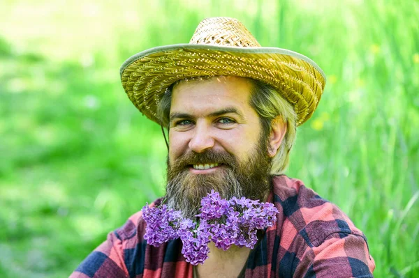 有胡子的乡下人快乐地享受生态环境中的生活。开紫丁香花的河马看起来很开心。留着胡子的男人，留着淡紫色的胡子，绿色的草色背景。生态友好型生活方式概念 — 图库照片