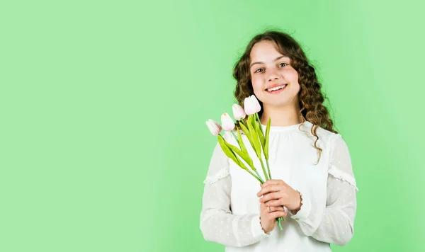 Wiosenny bukiet kwiatów. Szczęśliwego Dnia Kobiet. Międzynarodowy Dzień Dziecka. koncepcja Dnia Matki. Wesoła dziewczynka z kręconymi włosami. kwiaty tulipanów dla dziecka. szczęśliwa dziewczyna trzymać kwiaty tulipan. przestrzeń kopiowania — Zdjęcie stockowe