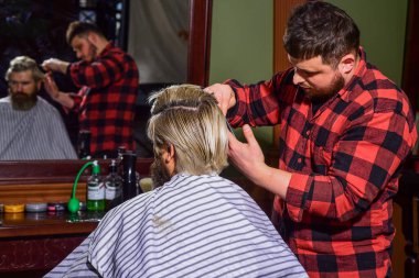 Kendini uyarılmış say. Uzun sarı saçlı adam, dikiz aynasından bakıyor. Saç kes. Berber, sakallı adam için kuaförlük yapıyor. Hipster müşteri saçını kestiriyor. Berber makası