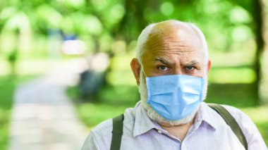 Karantina genişletildi. Kilitleme kısıtlamalarını gevşetiyorum. Salgın hastalık konsepti. Enfeksiyonun yayılma riskini sınırla. Kıdemli adam maskesi. Yaşlı insanlar yüksek riskli covid-19. Maske virüsten korunuyor. Maske tak.