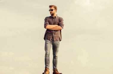 Güzel bir model. Gözlüklü iş adamı. Güven ve karizma. Maço, tıraşsız bir adam. Erkek modası. Çok moda görünüyor. Seksi erkek gökyüzü arka planı. Erkekler güzellik ve cinsellik. Gerçek erkekler.