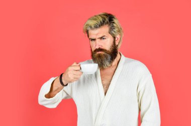 Kahvaltı konsepti. Bornozlu sakallı adam sabah kahvesinin tadını çıkar. İç çamaşırlı adam elinde kahve fincanı tutuyor. Sabah kahveyle başlar. Günlük Ritmini Anlamak. Kupalı sakallı adam.