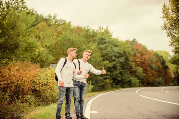 Un gesto de autoestop. Comience una gran aventura en su vida con autoestop. Compañia amigos viajeros autostop en carretera naturaleza fondo. Viajeros en camino. Amigos autoestopistas viajando — Foto de Stock