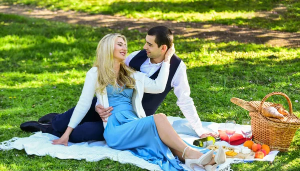 Vier de liefde. Vintage stijl. Verliefd stel geniet van picknick tijd en eten buiten. Verliefde man en vrouw. Voorjaarsdatum. Romantisch afspraakje. Paar knuffels ontspannen op groene weide met picknickmand — Stockfoto