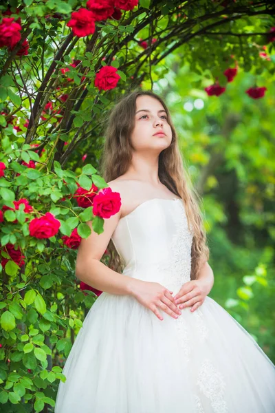 Small angel for bride. cute lady. happy childhood. beauty and fashion. pretty kid smell rose flower. spring and summer nature. little girl in garden. child enjoy blossom in park. Waiting for wedding — Stock Photo, Image