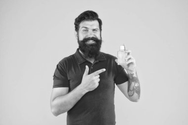 Parfüm seç. Misk kokulu madde, genelde temel notalarda kullanılır. Losyon spreyi. Parfüm ürünleri konsepti. Sakallı, yakışıklı adam şişe parfümü kullanıyor. Parfüm sürmüş.