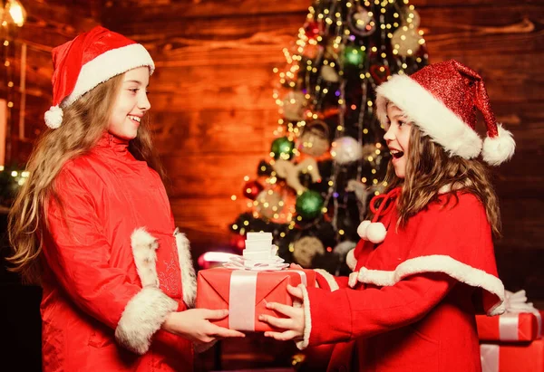 Flicka jultomte kostym hålla jul presentförpackning. Förbered överraskningspresent. Öppen gåva. Lyckliga ögonblick. Grabben ger julklapp till syster. Gratulerar närmast. Festlig atmosfär juldagen — Stockfoto