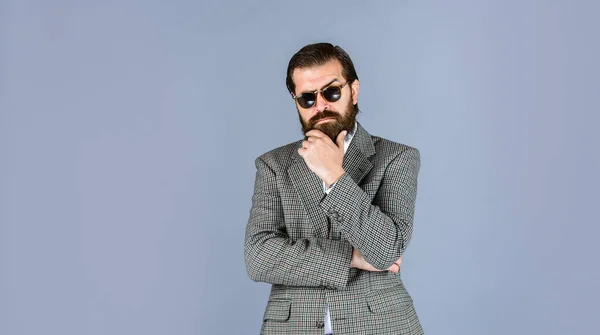 Hij draagt een wit shirt en een bril. Stijlvolle succesvolle man in pak poseren. Zakenman in pak. officiële kantoorlevensstijl. Een man met een baard. knappe en succesvolle man in duur pak — Stockfoto