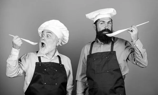Culinary dynasty. Mature bearded men professional restaurant cooks. Teaching culinary. Culinary book. Delicious recipe. Chef men cooking. Kitchen team prepare food. Family tradition. Eat concept