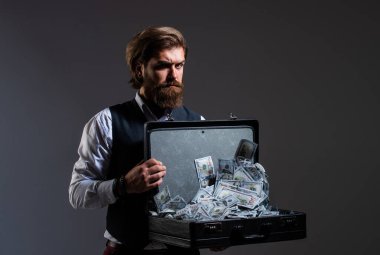 Banka kavramı. Para biriktiriyorum. Milyarder. Para çantası olan zengin bir iş adamı. Lüks ve başarı. İnsanoğlunun piyango kazananları. Turnayı gözünden vurdum. Adam para dolu bavulu tutuyor.