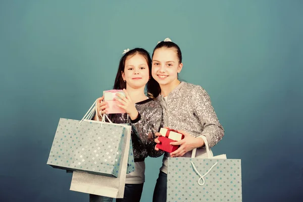 Filles sœurs amis avec sacs à provisions fond bleu. Achats et achats. Vendredi noir. Vente et rabais. Des paquets d'enfants. Journée shopping. Mode pour enfants. Chaque produit qui vous est livré — Photo