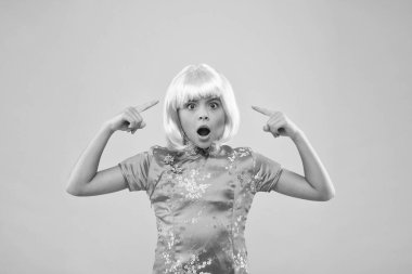 - Neler oluyor? Kuaför salonu. Moda ve güzellik. Şaşırmış kız peruğu işaret ediyor. Çin usulü parti çocuğu. Pembe peruklu küçük Çinli kız. Geleneksel Çin elbisesi giyen çocuk. Retro Çinli kız.