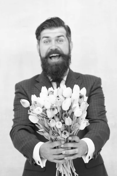 これは君のためだ。春が来る。挨拶だ。髭の男チューリップ花束。女の日だ。3月8日。春の贈り物。髭を生やした男が花でヒップスター。春を祝う。驚きだ。チューリップの紳士 — ストック写真