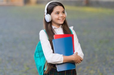 Müzik insanlığın evrensel dilidir. Mutlu çocuk dışarıda müzik dinler. Küçük çocuk müzik çalarken kulaklık takıyor. Müzik okulu. Yeni teknoloji. Modern hayat. Eğitim ve öğrenim. Kulak eğitimi