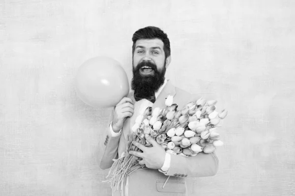 Shower love upon her with flowers. Happy hipster hold tulips and balloon. Love gift. Romantic bouquets for Valentines day. Proposal flowers. Love and romance. Send love flowers to your sweetheart — Stock Photo, Image