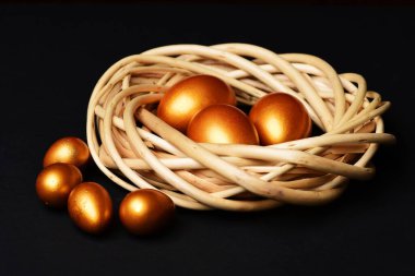 Örülmüş ahşap çelengin içinde altın rengine boyanmış geleneksel yumurtalar