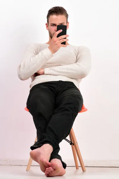 Guy segura telefone e lê mensagem ou assiste vídeo — Fotografia de Stock