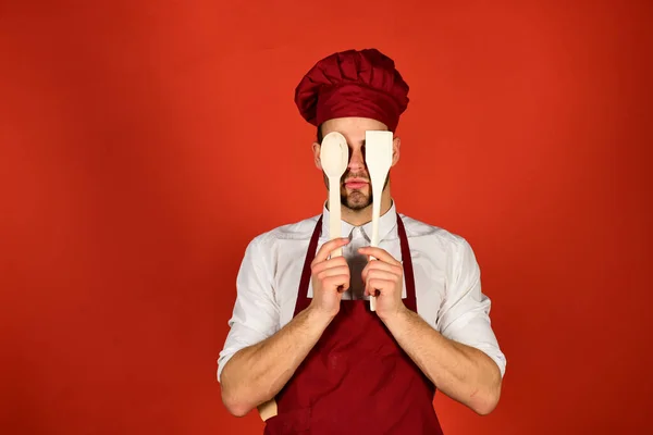 Chef med dolt ansikte håller träsked och spatel — Stockfoto