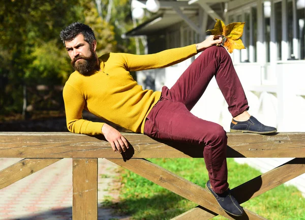 Cara com barba encontra-se no corrimão de madeira — Fotografia de Stock