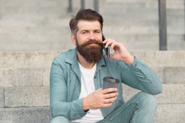 Sabahlarına enerji katıyorsun. Sakallı adam telefonda konuşurken kahve içer. Kahveni götür. Kahve molası. Kahve ve iletişim. Yeni teknoloji. Modern hayat