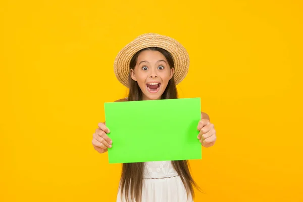 Es hora de relajarse. despreocupado belleza mostrar hoja de papel. espacio de copia. chico sorprendido en sombrero de paja. niño anuncia actividad en la playa. Feliz infancia. vacaciones de verano y vacaciones. ventas de moda de temporada niño —  Fotos de Stock