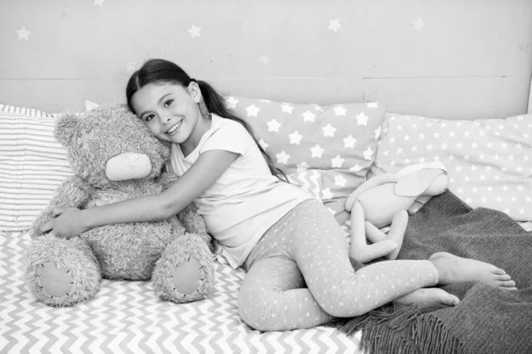 Ideal zum Kuscheln. Glückliches Kind hält Teddybär-Spielzeug im Bett Kleines Mädchen spielt mit Stofftier. Spielzeugladen oder Geschäft. Kinderspielzeug. Spielzeit. Kindheitsspiele — Stockfoto