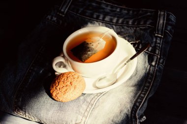 Bardak dolu çay, yakın çekim. Bitki yeşili ya da siyah yaprak. Çay demleyen seramik bardak. İlham ve huzurlu bir ruh hali. Papatya çayı içiyorum. Kupa kupası sıcak çay ve yulaflı kurabiye. Hızlı atıştırma konsepti