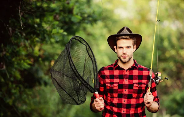 Pescar en mi hobby. Concepto de fin de semana. Pescador Hipster con varilla girando red. Espero una buena pesca. Día de pesca. Tipo guapo en camisa a cuadros con equipo de pesca fondo de la naturaleza — Foto de Stock