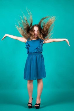 Küçük kızın uzun gür saçları var. Rüzgarlı kıvırcık saçlı çocuk. Kadın kuaför salonu. Güzellik ve moda. Mutlu çocuk zarif görünüyor. Yüksek topuklu bir çocuk. Mutlu çocukluk