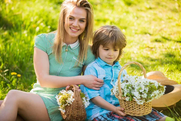 Spring season. Happy holidays. Mother and cute son having fun. Spring holiday. Weekend leisure. Explore nature. Wildflowers in field. Motherhood happiness. Cowboy family collecting spring flowers