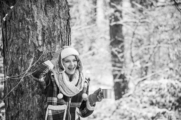 Na dworze w mroźny dzień. podróże i wędrówki. Dziewczyna turysta pić filiżankę gorącej herbaty. Rozgrzej się. zimowy napój. Dziewczyna lubi opady śniegu. Kobieta w rękawiczkach i kapeluszu pijąca herbatę. Świąteczna atmosfera — Zdjęcie stockowe