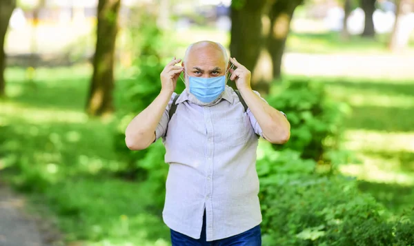 Beperk de verspreiding van infecties. Oudere man gezichtsmasker. Ouderen lopen het grootste risico op covid-19. Versoepeling van vergrendelingsbeperkingen. Draag een masker. Quarantaine verlengd. Masker beschermt tegen virus. Pandemisch concept — Stockfoto