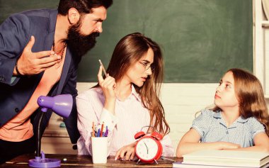 Aşırı korumacı ebeveynlik tarzının en büyük dezavantajı yetersiz hazırlanmış çocuklar. Aşırı korumacı bir aile. Aşırı korumacı ebeveynlik tarzı. Ödev yapan küçük bir kız. Baba anne çocuğa öğretiyor. Akıllı aile.