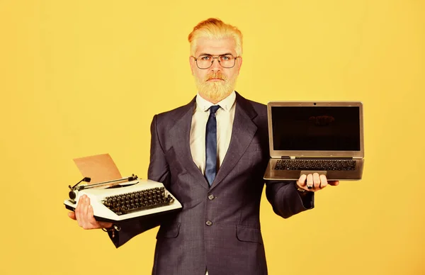 Learn it easy way. successful businessman use retro typewriter and modern laptop. man dyed beard hair. computer or typewriter. new and old technology. modern digital business. vintage typewriter