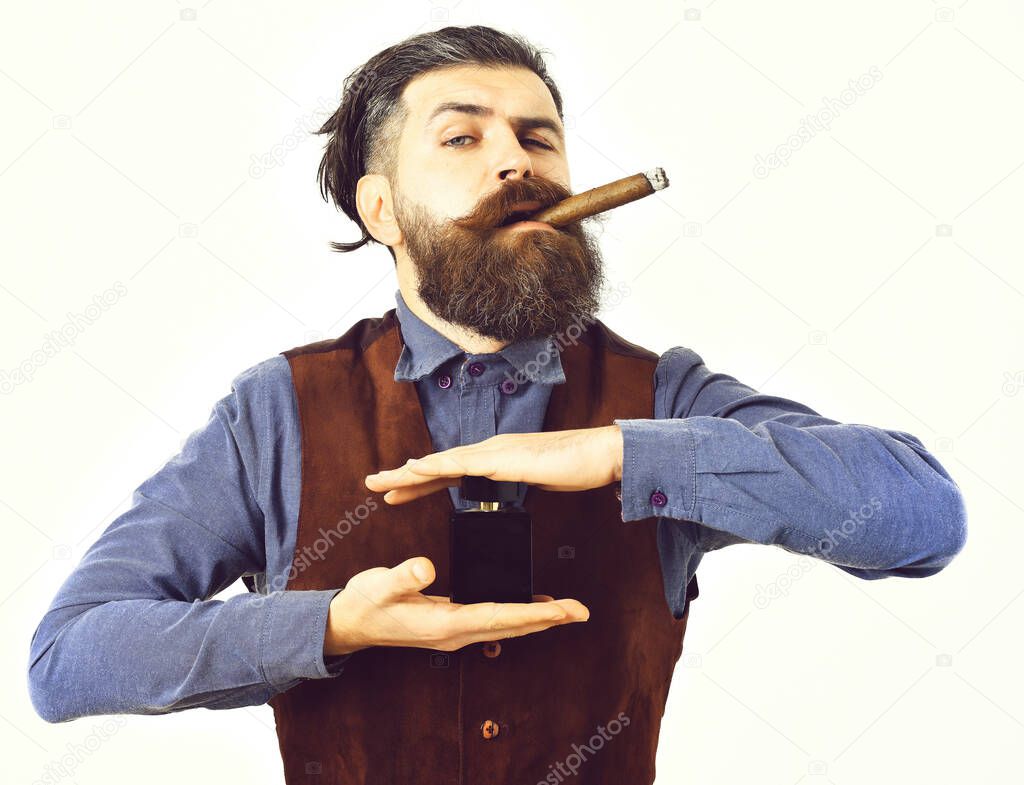 bearded man smoking cigar with serious face, holding perfume