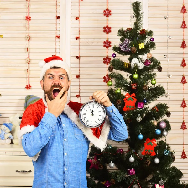 Santa Claus s divokou tváří v blízkosti vánoční strom na pozadí — Stock fotografie