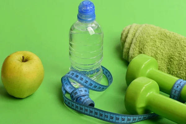 Barbells près de pomme verte juteuse. Haltères de couleur vert vif — Photo