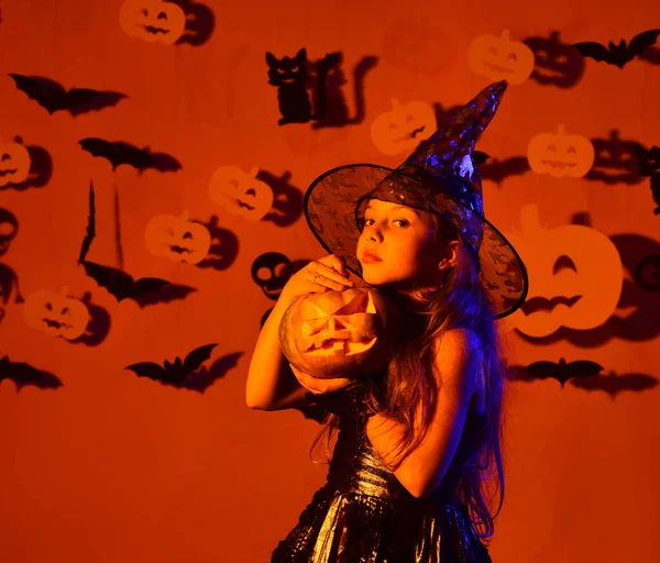 Gelukkig Halloween concept. Leuke kleine heks met een grote pompoen. — Stockfoto