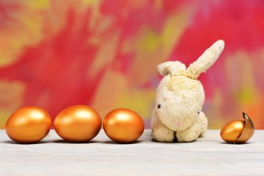 Renkli arka planda tavşan oyuncağı ve paskalya yumurtası