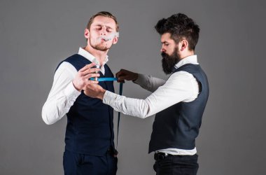 Dikiş dikmek için ölçü alan terzi, gri arkaplan.