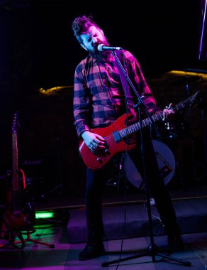 Ön adam konsepti. Bağıran suratlı adam gitar tutuyor.,