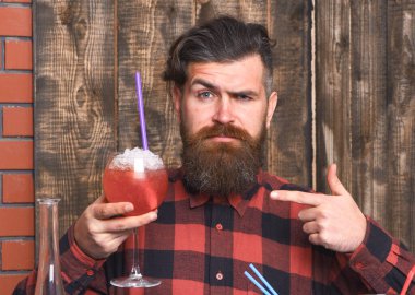 Adam ahşap arkaplanda kokteyli işaret ediyor..