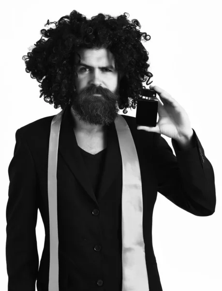 Hipster caucasien en costume et perruque bouclée noire tenant parfum — Photo