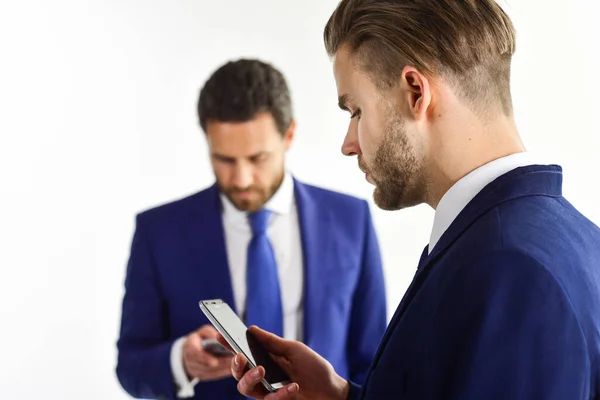 Hombres de traje o hombres de negocios con el teléfono inteligente de retención de cara ocupada — Foto de Stock