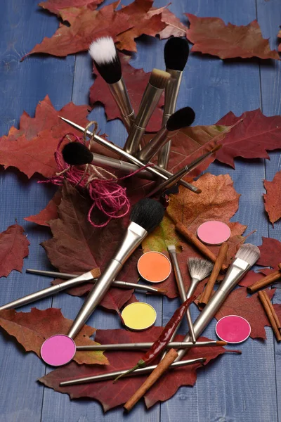 Herfst make-up benodigdheden op houten tafel. Cosmetica, penselen, oogschaduwen, — Stockfoto