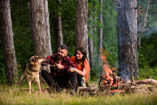 Couple with german shepherd dog near bonfire, — Stock Photo, Image